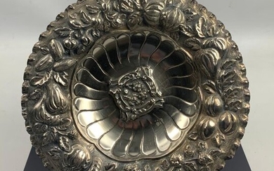 Important dish in embossed and chiselled silver decorated with flowers and fruits.