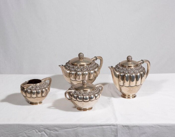 Tea and coffee set in silver plated metal decorated with gadroons and friezes of roses in relief including a teapot, a coffee pot, a sugar bowl, a tray and a milk jug.