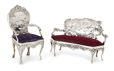Two Edwardian novelty silver pincushions, London, 1902, William Comyns, designed as a sofa and chair, both with velvet seat pincushions and putti-decorated chair backs, chair 14.2cm high, sofa 9.6cm high (2)