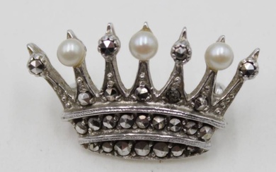 Une broche en argent en forme de couronne, ornée de perles et de marcassites. Argent...