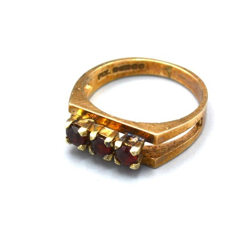 A 9ct Yellow Gold Dress Ring set with three garnets within a...