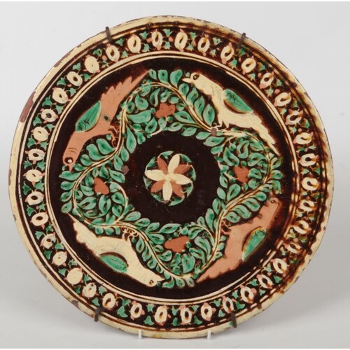 A Bombay School of Arts pottery charger. Decorated with bird...