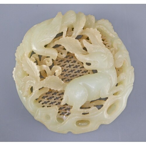 A Chinese pale celadon jade circular plaque, carved in relie...