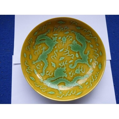 A Chinese porcelain scrafitto dish; three green dragons chas...