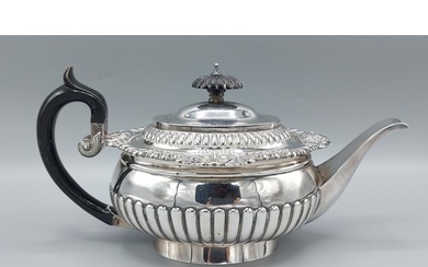 A George III silver teapot of half lobed form with shaped eb...