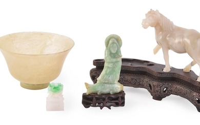 A Jadeite carving of a figure standing on a fish