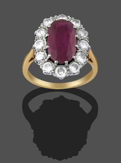 A Ruby and Diamond Cluster Ring, the central oval cut ruby within a border of round brilliant...