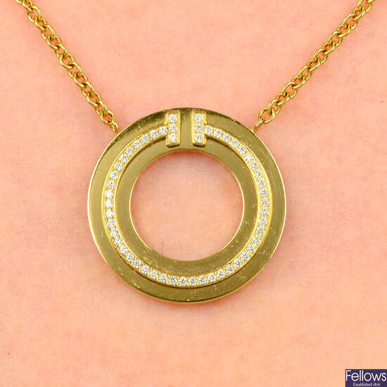 A diamond 'T' circle pendant, by Tiffany & Co., later applied to a belcher-link chain, by Fope.