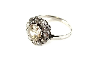 A diamond daisy cluster ring, with central round brilliant...