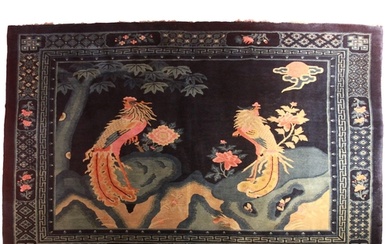 A good Chinese blue ground rug depicting 2 exotic birds amon...