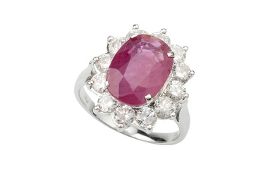 A ruby and diamond cluster ring, the oval mixed cut...