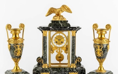 A three-piece mantle garniture clock and urns, gilt bronze on green marble, Empire style. France