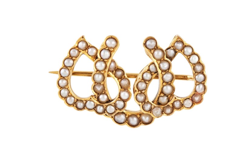 AN ANTIQUE TRIPLE HORSESHOE BROOCH, set with seed pearls, mo...