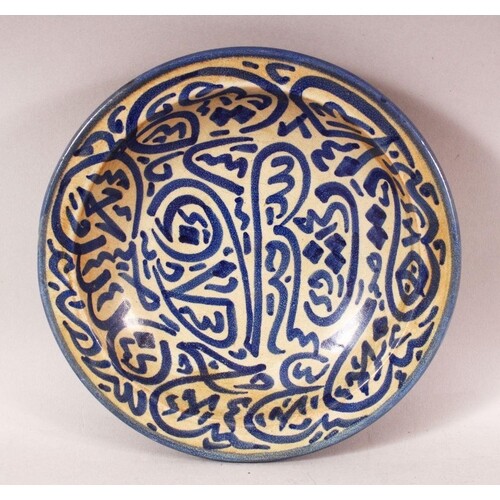 AN ISLAMIC CIRCULAR POTTERY BOWL, painted with stylised call...