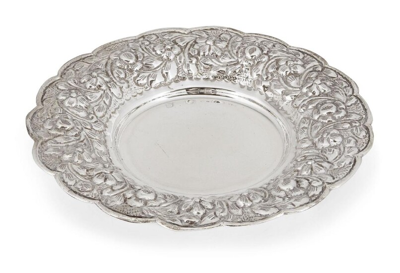 An Egyptian silver repousse dish, with marks for 900 silver fineness, post 1946, the shaped circular dish raised on three bracket feet, the rim designed with repousse flowers, 20.5cm dia., approx. weight 9.4oz