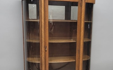 Circa 1900 1/4 cut Oak Curved Glass China Closet with hand carved cresting, claw feet & mirror back.