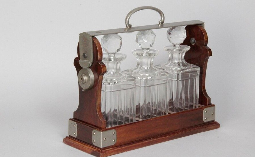 ENGLISH WHISKY CELLAR THE TANTALUS, in mahogany and metal with three carved glass decanters and their stoppers, from Maison BETJEMANN London. With these keys. H: 29 x W: 36 x D: 13 cm
