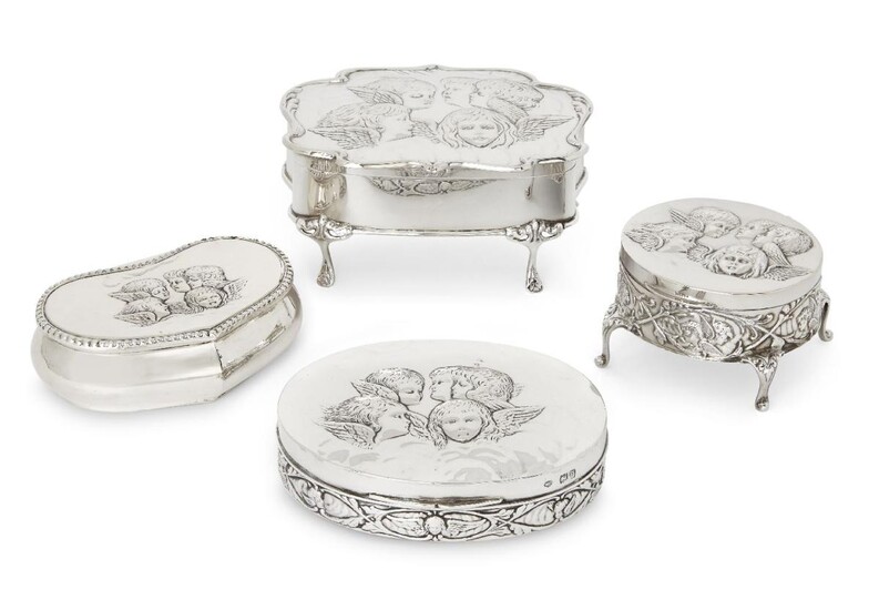Four Victorian and Edwardian silver trinket boxes, the lid of each decorated with winged putti, the group comprising an example raised on four feet, Birmingham, 1903, Henry Matthews, 6.7cm high, 14.2cm wide, a smaller example on four feet...