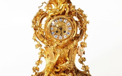 Horloge de cheminee en bronze dore dans le style Louis XV, richement decoree delements decoratifs...