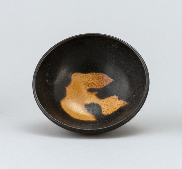 CHINESE JIZHOU POTTERY TEA BOWL With black glaze and a gilt leaf in base of interior. Foot unglazed. Height 1.5". Diameter 3.5".