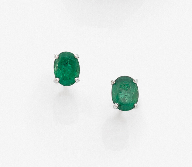 Pair of EAR CLOUSES in white gold (750‰) each set with an oval emerald. Greyish.