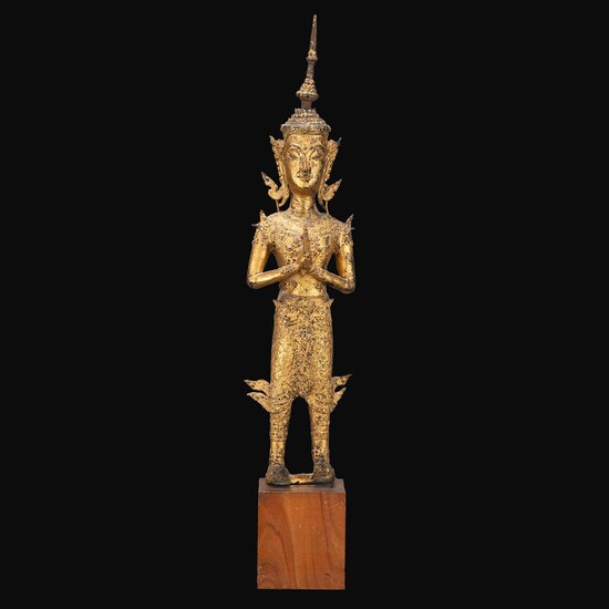STATUE en bronze, laqué et doré, représentant le Bouddha en pied, les yeux mi-clos, les cheveux et l'ushnisha bouclés, les mai...