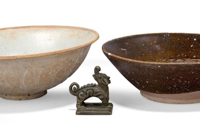 Two Chinese pottery bowls and a bronze seal, the bowls 14th-15th century, one bowl moulded with stiff lotus leaves to the exterior and covered in a pale translucent glaze, the other with a thin treacle glaze, 17cm diameter, the seal cast with a...