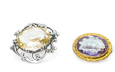 Two quartz brooches. Comprising an Amethyst brooch, in yellow precious...