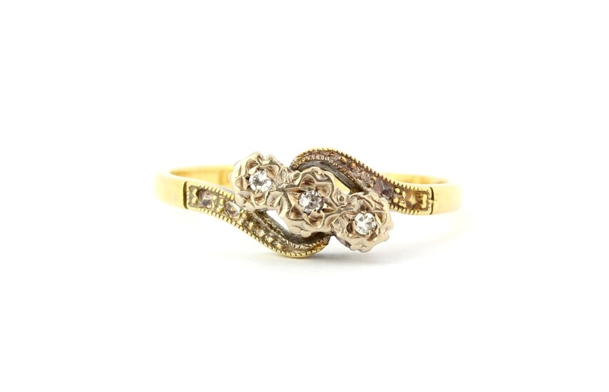 A 18ct gold and platinum diamond set crossover ring, (L.5).