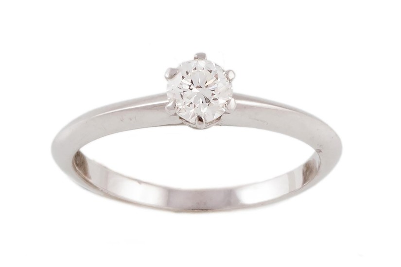 A DIAMOND SOLITAIRE RING, signed Tiffany & Co, with one roun...