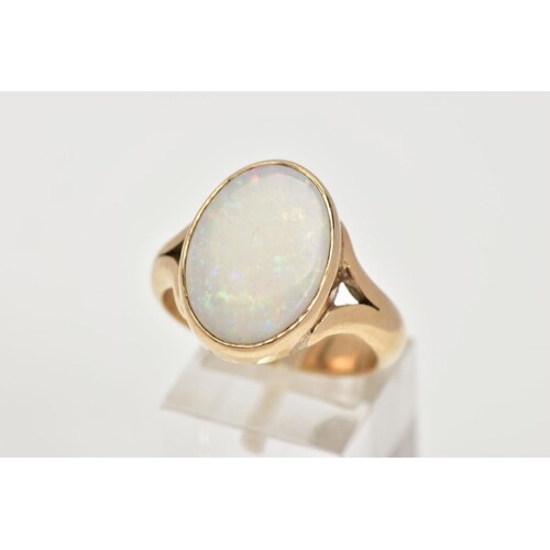 A HEAVY 9CT GOLD OPAL RING, designed with an oval cut opal c...