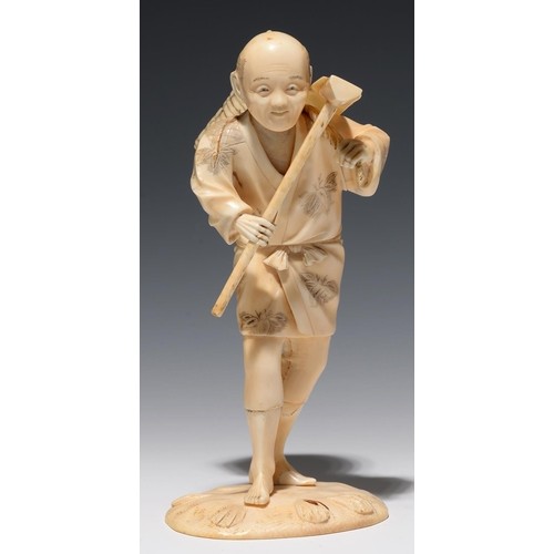 A JAPANESE SECTIONAL IVORY FIGURE OF A FARMER CARRYING A BAS...