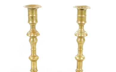 A PAIR OF MID 18TH CENTURY SEAMED CAST BRASS CANDLESTICKS wi...