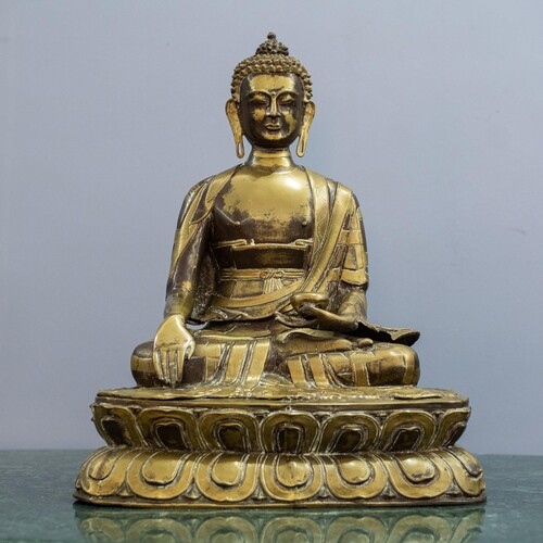 A Patinated Bronze Figure of the Buddha, seated on a double-...
