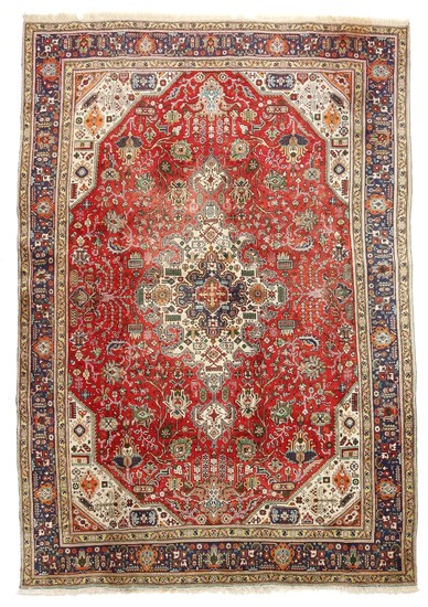 A Persian Täbriz carpet, classic medallion design with ornaments, flowers and foliage on red base. 20th century. 346×238 cm.