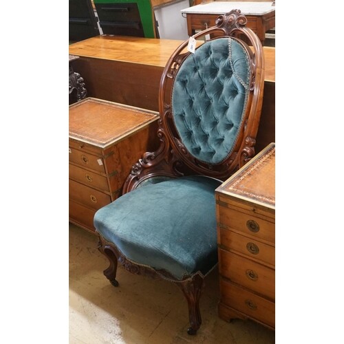 A Victorian carved mahogany spoon back salon chair with butt...