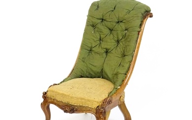 A Victorian mahogany nursing chair with a scrolled, deep but...