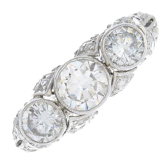 A diamond three-stone ring. Of novelty design, the