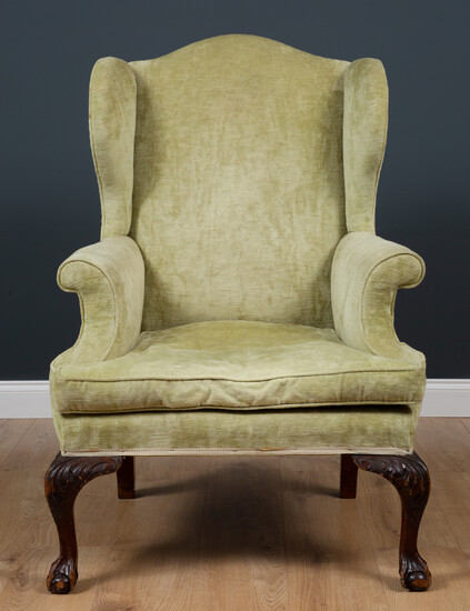 A late 19th century Georgian style green upholstered wingback armchair...