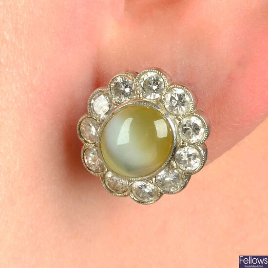 A pair of cat's-eye chrysoberyl and brilliant-cut diamond cluster earrings.