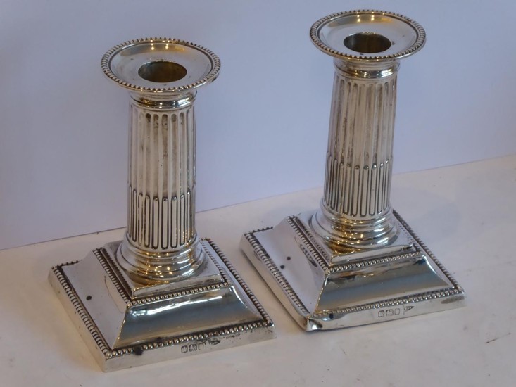 A pair of dwarf silver table candlesticks; modelled in the c...