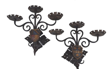 A pair of wrought-iron three-light wall appliques, late 20th century, each with scrollwork supported mounted with a shield, 31cm high (2)