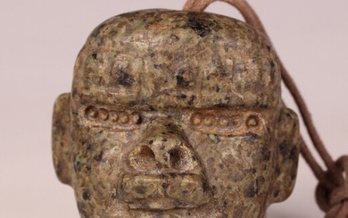 A pre-Columbian Olmec style carved mottled green hardstone transformation mask, probably 900-450 BC
