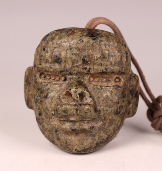 A pre-Columbian Olmec style carved mottled green hardstone transformation mask, probably 900-450 BC
