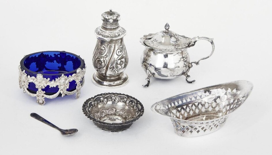 A small group of silver comprising: a Victorian silver pepper with hinged lid, London, c.1885, Rosenthal, Jacob & Co.; a silver mustard, Chester, c.1901, Jay, Richard Attenborough & Co; a blue glass salt in pierced silver mount, stamped 800; a...