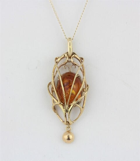 A yellow metal (tested 9ct gold) amber pendant and chain, L. 5cm.