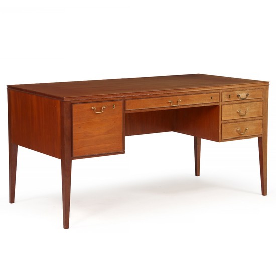 Danish cabinetmaker: Mahogany desk with tapering legs. Front with five profiled drawers with brass handles.