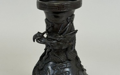 INOCHINE, XXe. Petit vase balustre en bronze à décor de dragons reposant sur trois pieds....