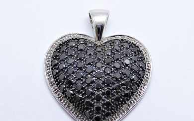 PENDENTIF en or blanc 18K (750/°°) figurant un cœur orné de diamants noirs et bordé...
