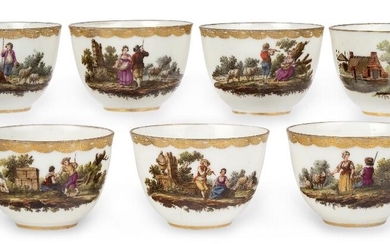 Seven Amstel porcelain teabowls, c.1785, blue script marks and incised marks, painted with pastoral vignettes with figures at various pursuits in landscapes with trees, monuments, buildings, livestock and ruins below elaborate gilt borders, the...